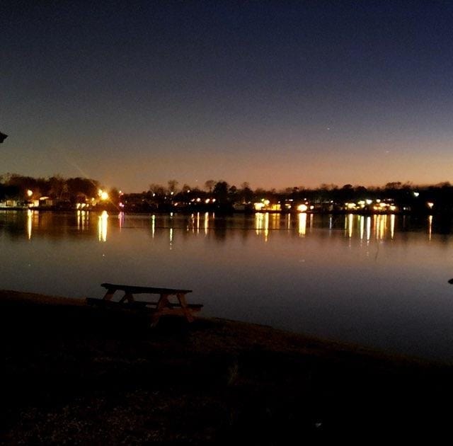 Waterfront at night with lights reflecting on Lake Conroe
